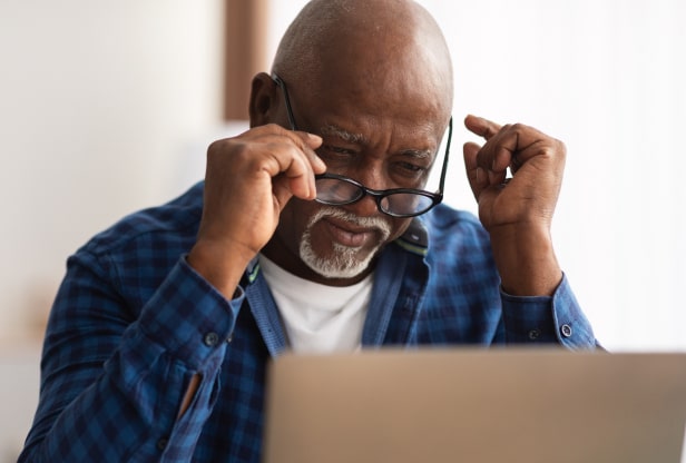 Older man struggling to look at computer