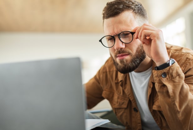 Man squinting at laptop