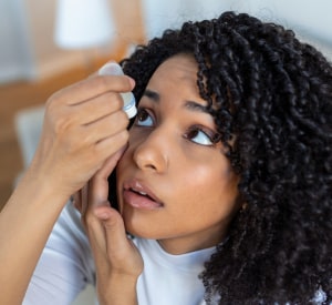 Woman putting in dry eye drops